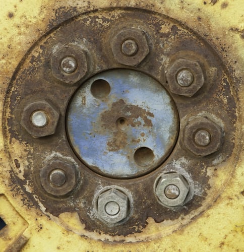 Rusty bolts in yellow wheel of tractor